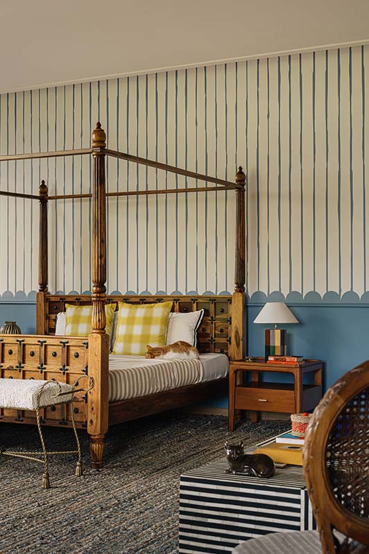 The Anderson-themed guest bedroom features hand-painted striped wallpaper and a monochrome striped table by House of Things paired with India Mahdavi x H&M cushions, a carpet from Mody’s collection and a vase by Eeshan Kashyap. (Image Credits: Ishita Sitwala)