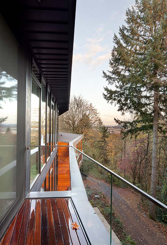 An elevated deck offers sweeping views of the forest, blending the home seamlessly with its natural surroundings. (Image Credit: Jeremy Bittermann) 